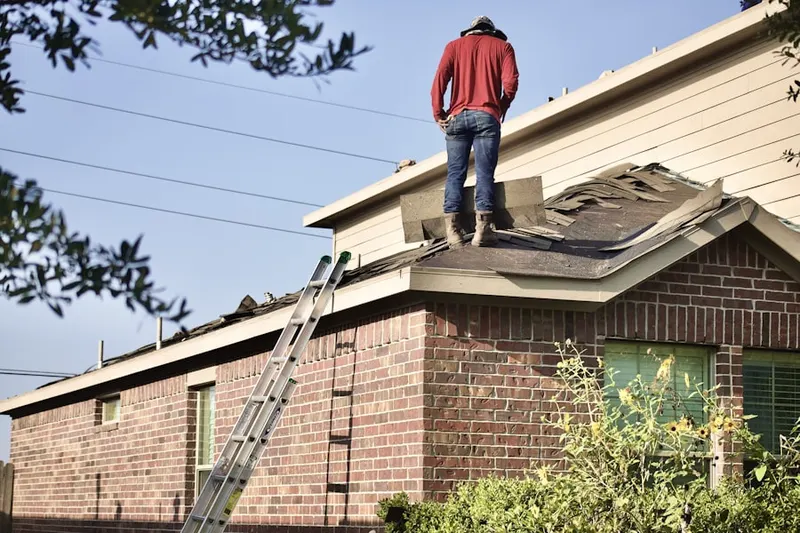 Professional roofer working on a residential roof in Mart